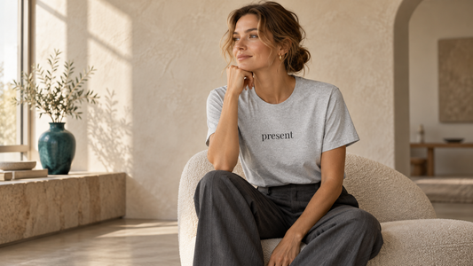 Editorial lifestyle image for 'Why One Word Can Feel More Personal Than a Loud Graphic: The Psychology of Minimal Statement Tees', styled in warm neutral Feliz Y Arte tones for fall / evergreen.