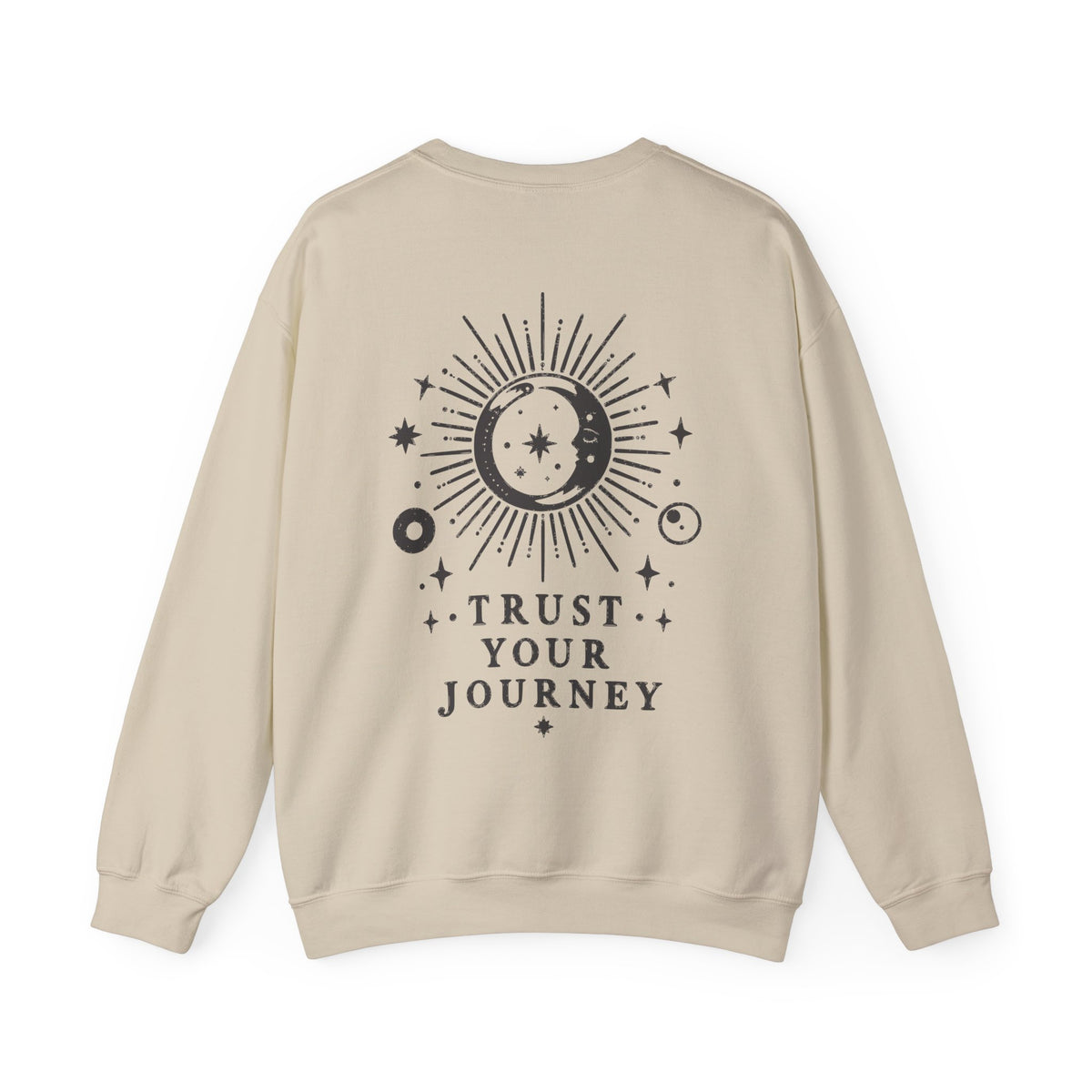 A beige crewneck sweatshirt shown from the back, featuring a black celestial graphic of a sun and moon with stars and the text 'TRUST YOUR JOURNEY'.