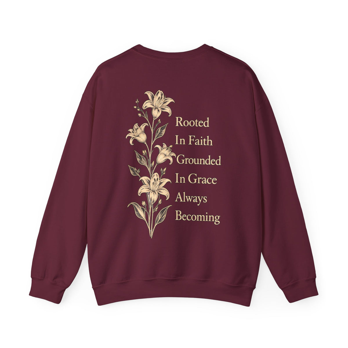 A maroon crewneck sweatshirt shown from the back, featuring a vertical graphic of beige lilies and the text 'Rooted In Faith Grounded In Grace Always Becoming' in a matching beige serif font.