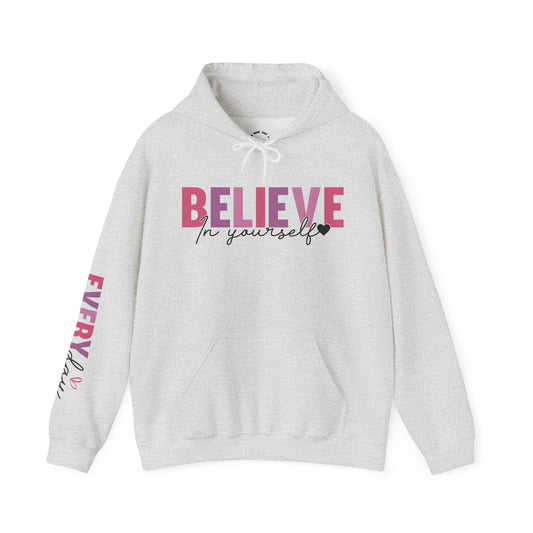 A light heather gray pullover hoodie with a graphic on the chest reading 'BELIEVE In yourself' in pink and black, plus 'EVERYDAY' printed down one sleeve.