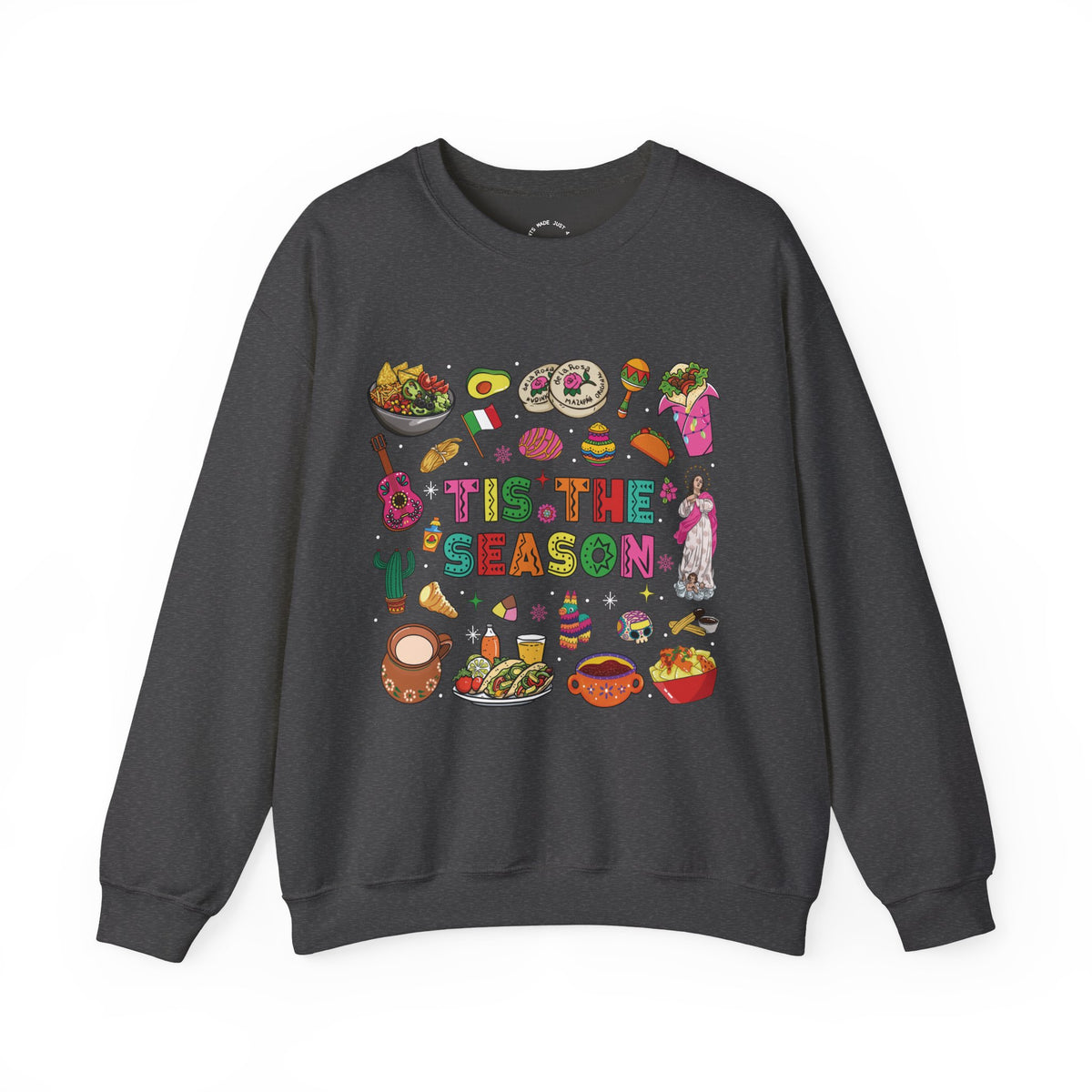 A dark gray crewneck sweatshirt featuring a colorful graphic print on the front with the text 'Tis the Season' surrounded by various cozy mexican illustrations like hot cocoa, burritos, tacos, pinata, and more seasonal traditions.
