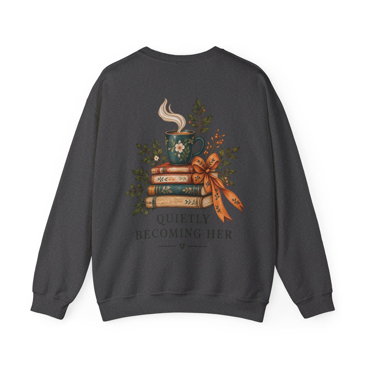 A dark gray crewneck sweatshirt featuring a graphic print of a steaming mug, stacked books, a bow, and the text 'QUIETLY BECOMING HER' on the back, shown against a plain white background.