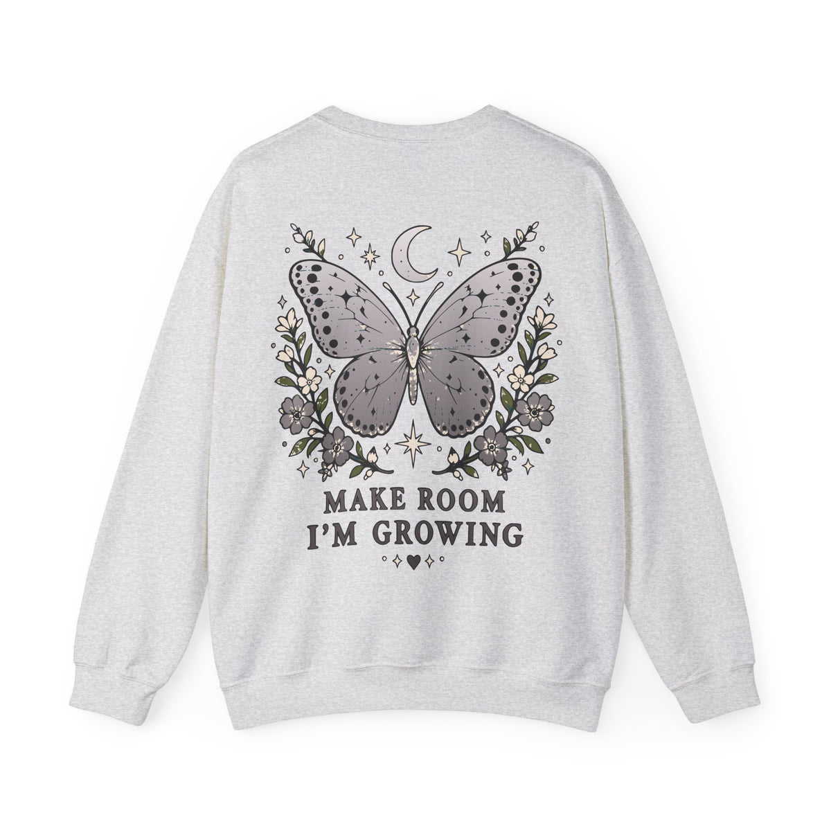A light heather gray crewneck sweatshirt shown from the back, featuring a graphic of a butterfly surrounded by flowers, a crescent moon, and stars, with the text 'MAKE ROOM I'M GROWING' printed below.