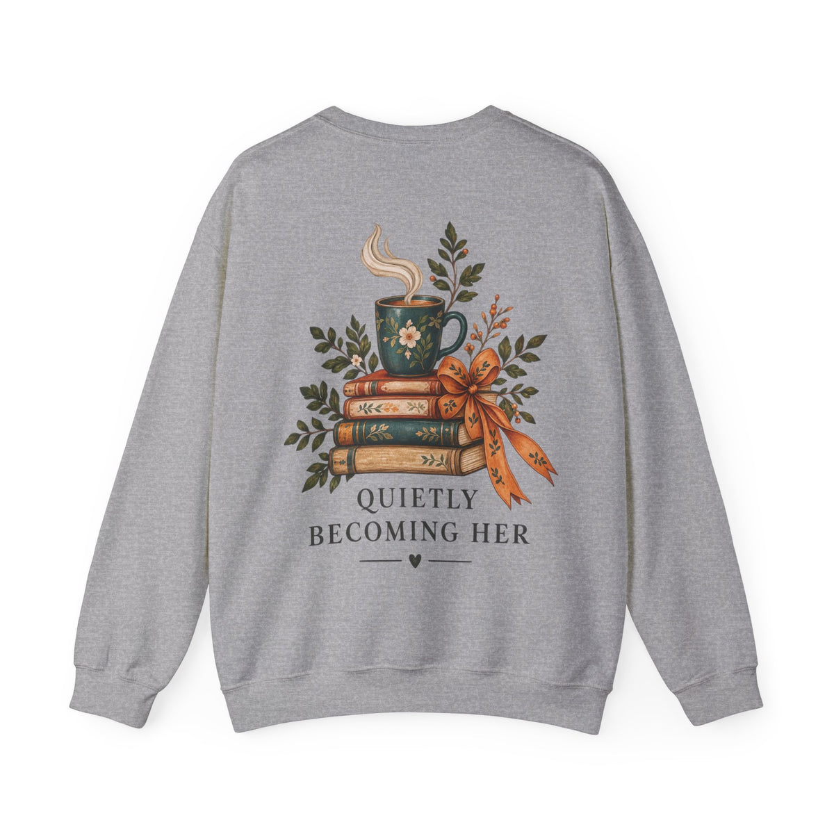 A heather gray crewneck sweatshirt shown from the back, featuring a graphic of a steaming mug on a stack of books with a ribbon, surrounded by leaves, and the text 'QUIETLY BECOMING HER'.