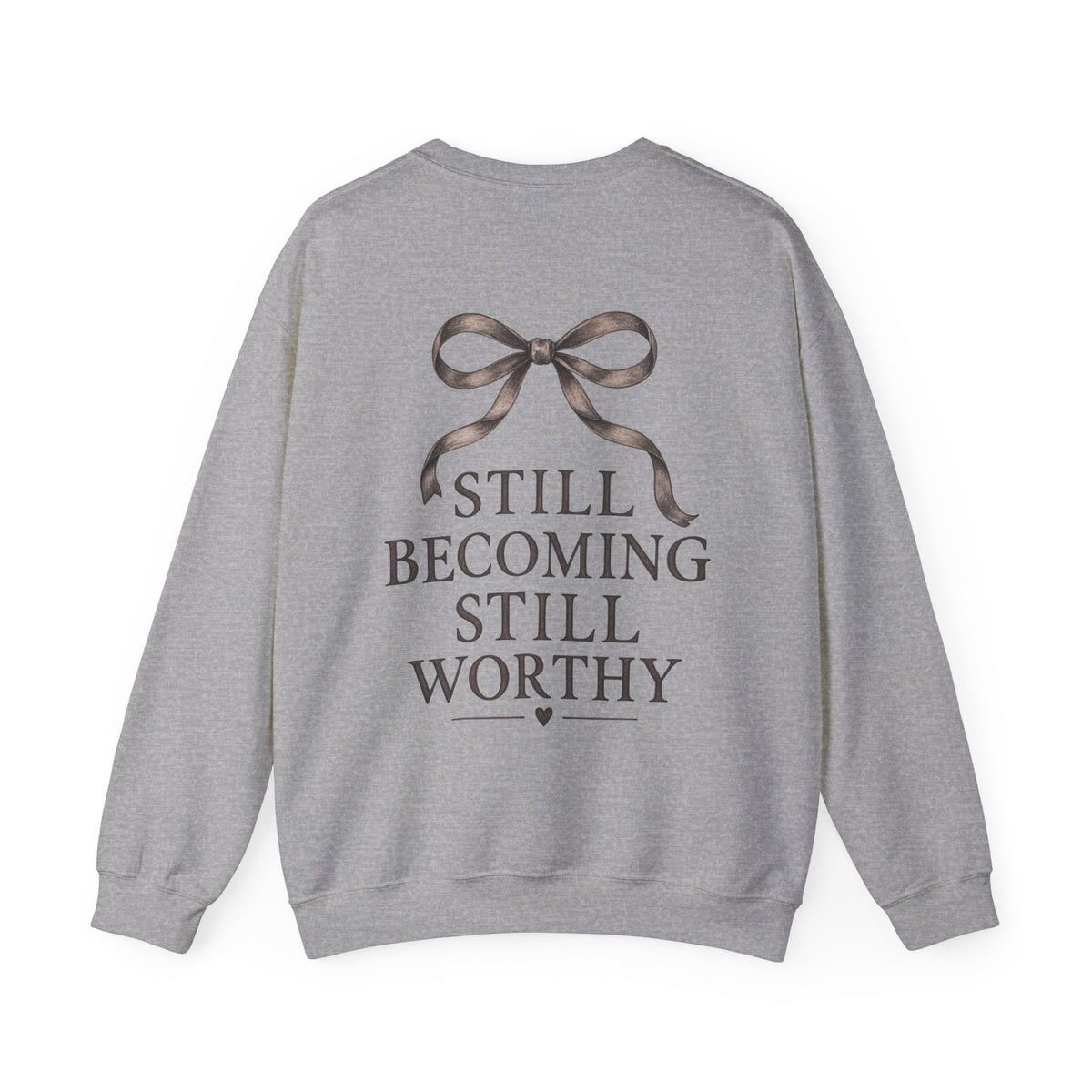 Gray sweatshirt shown from the back, featuring a dark brown ribbon graphic above the text 'STILL BECOMING STILL WORTHY'.