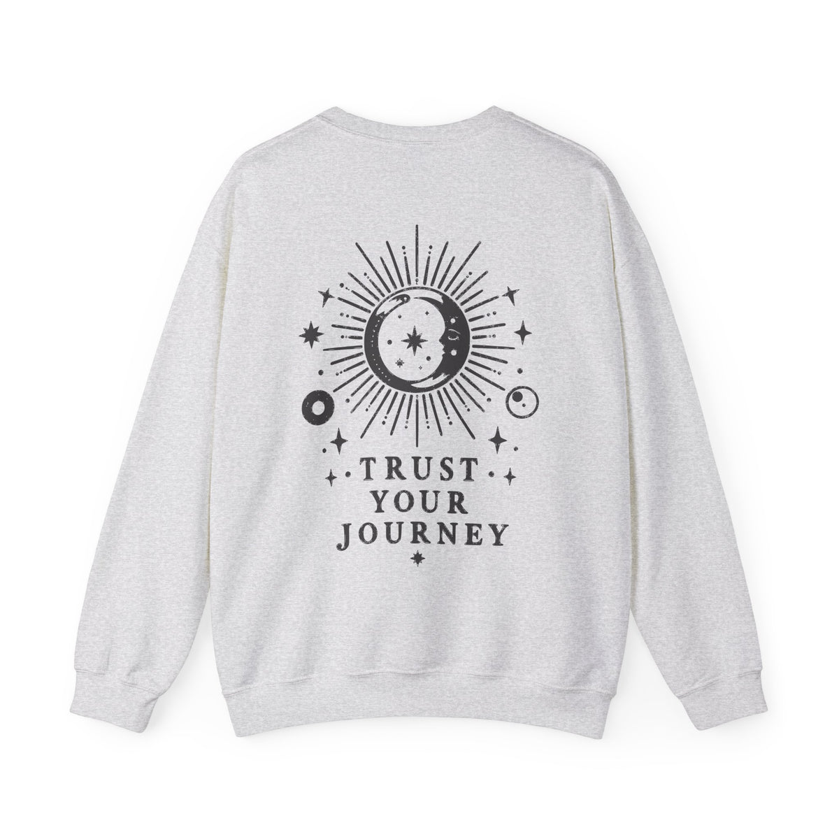 A light heather gray crewneck sweatshirt shown from the back, featuring a black celestial graphic of a sun and moon with the text 'TRUST YOUR JOURNEY'.