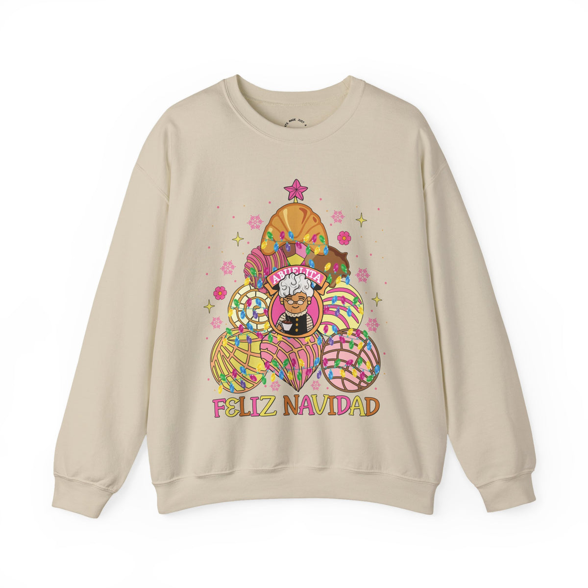 A beige crewneck sweatshirt featuring a colorful graphic of Abuelita in a festive, patterned concha christmas tree with the text 'FELIZ NAVIDAD' printed below, displayed on a clean white background.
