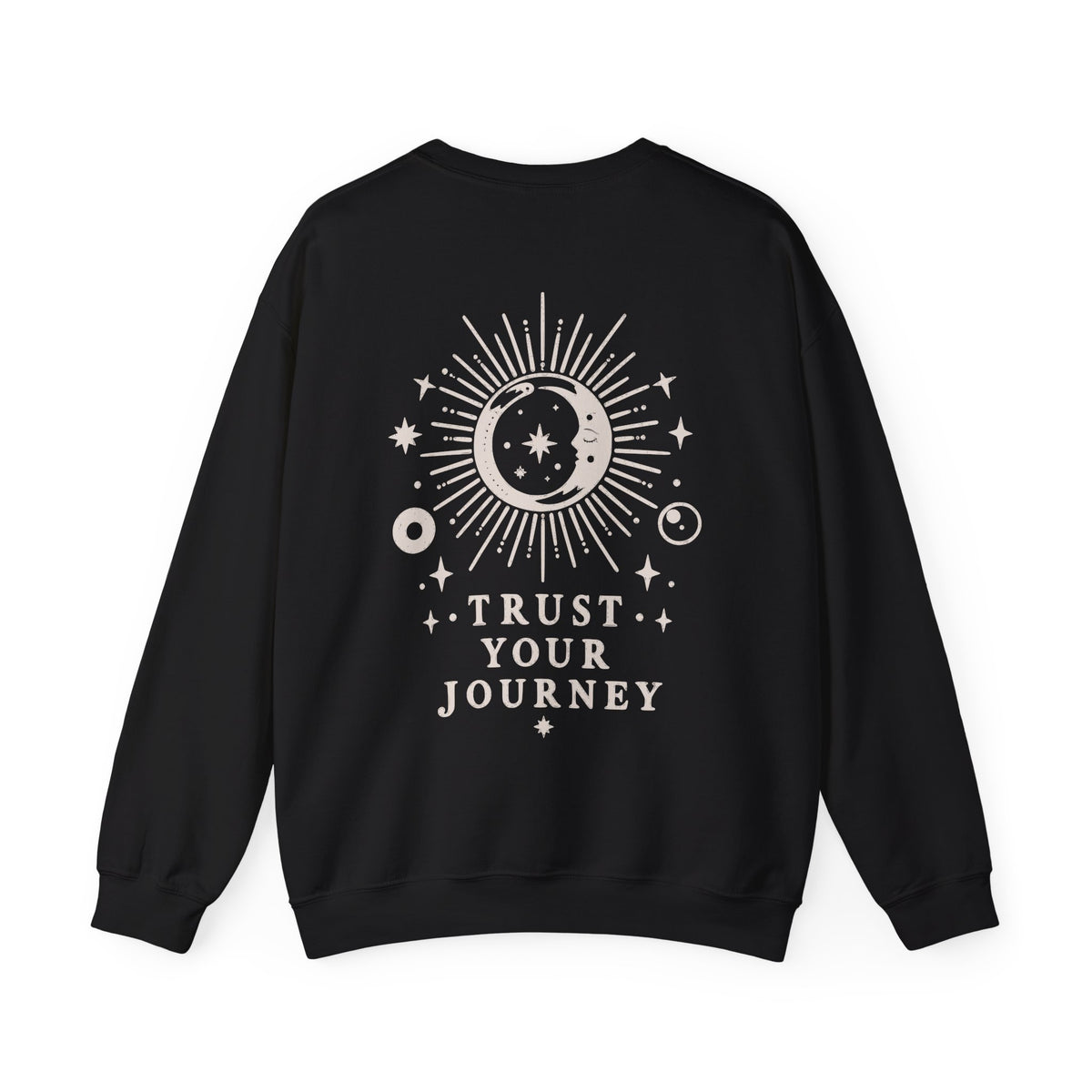 A black crewneck sweatshirt with a cream celestial graphic on the back featuring a sun, moon, stars, and the text 'TRUST YOUR JOURNEY'.