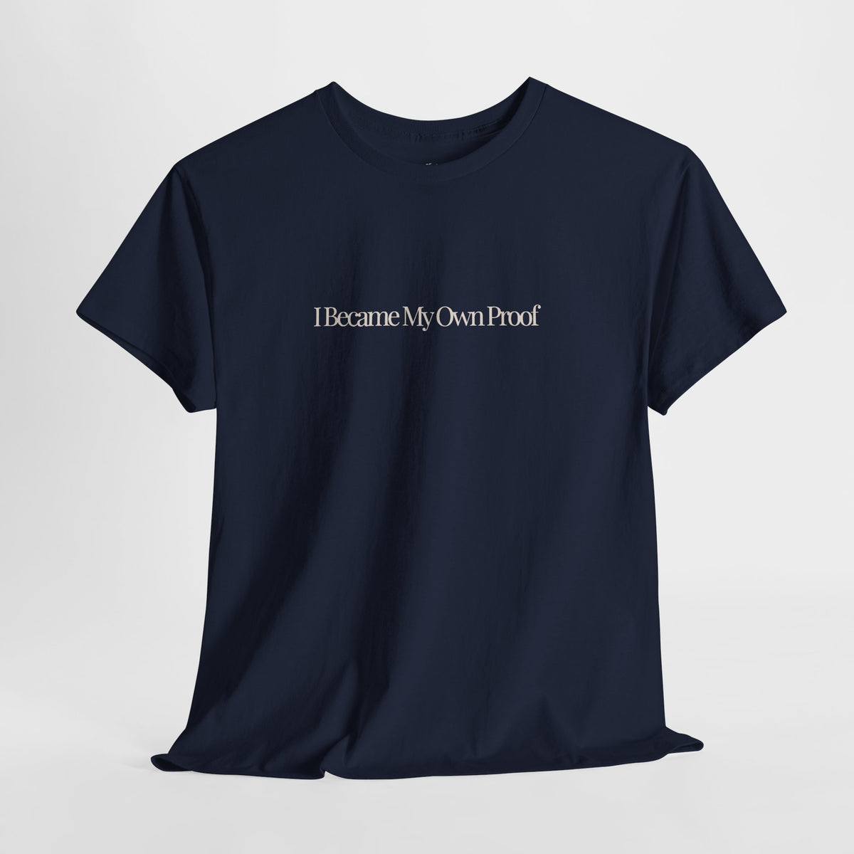 Navy t-shirt with 'I became my own proof' in a cream serif text across mid-chest area.
