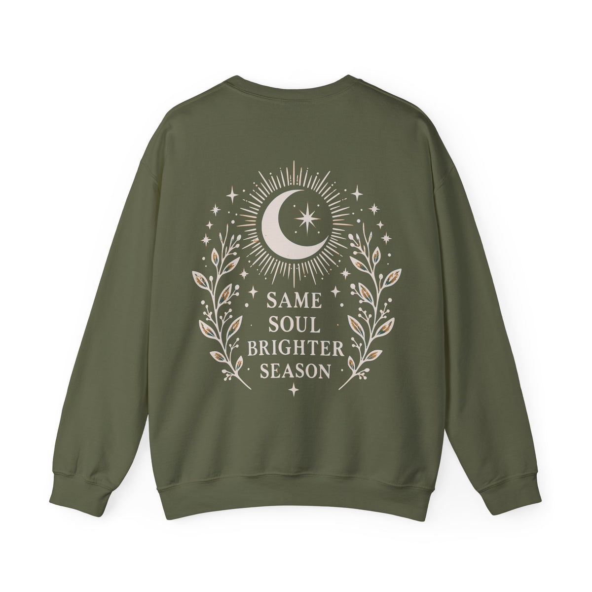 An olive green crewneck sweatshirt shown from the back, featuring a cream-colored graphic of a crescent moon, stars, and leafy branches surrounding the text 'SAME SOUL BRIGHTER SEASON'.