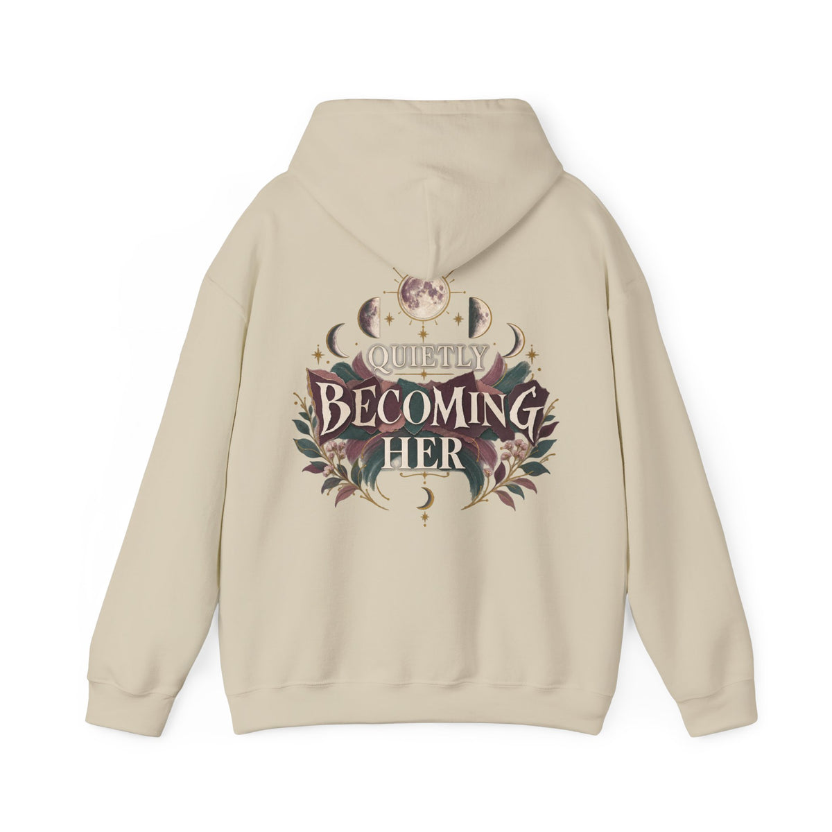 A beige pullover hoodie shown from the back, featuring a large graphic print with the text 'Quietly Becoming Her' surrounded by floral and celestial motifs in muted maroons, green, and gold tones.