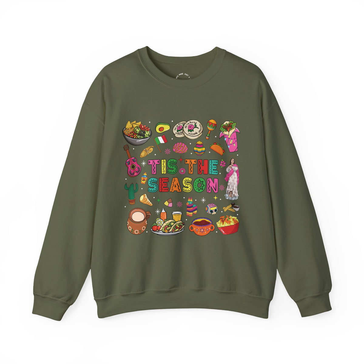 An olive green crewneck sweatshirt featuring a colorful graphic print on the front with the text 'Tis the Season' surrounded by various cozy mexican illustrations like hot cocoa, burritos, tacos, pinata, and more seasonal traditions.