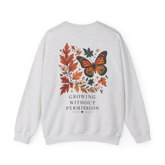 A light heather gray sweatshirt shown from the back, featuring a graphic print of a butterfly surrounded by autumn leaves and the text 'GROWING WITHOUT PERMISSION' in dark gray.
