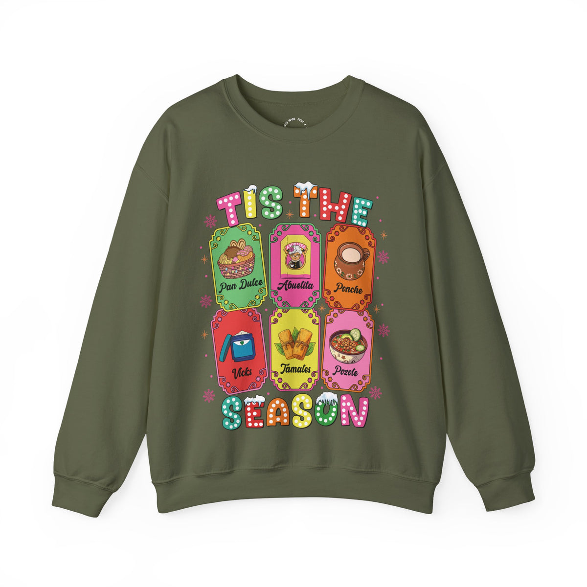 An olive green crewneck sweatshirt featuring a colorful graphic print of six Christmas-themed ticket illustrations with Latino traditions with the text 'TIS THE SEASON' in a retro, bubbly font.