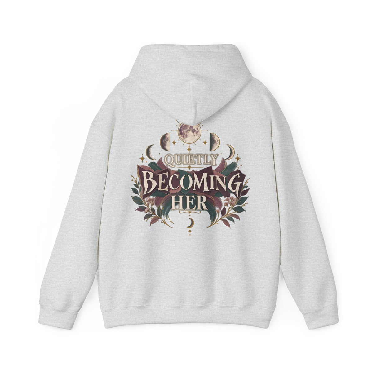 A light heather gray pullover hoodie shown from the back, featuring a large graphic print with the words 'Quietly Becoming Her' surrounded by decorative floral and celestial motifs in muted maroons, green, and gold tones.
