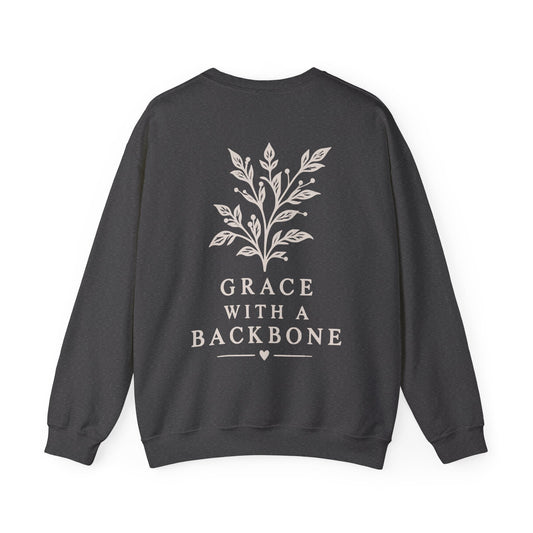 A dark gray crewneck sweatshirt with a cream graphic of a leafy branch and the text 'GRACE WITH A BACKBONE' printed on the back, shown against a plain white background.