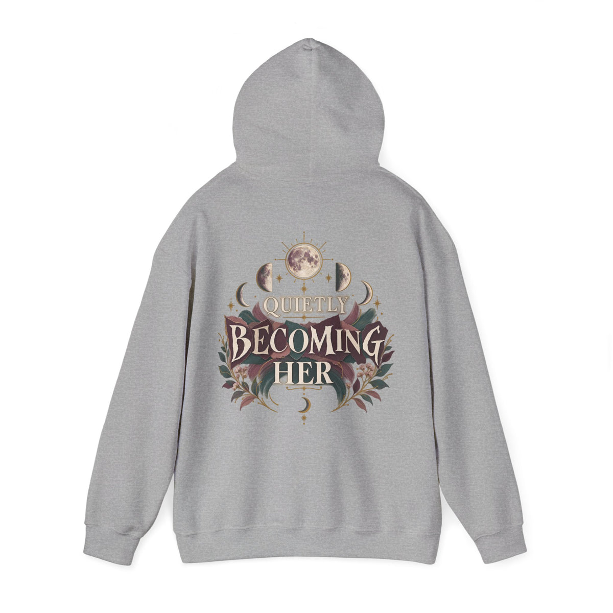 A light gray heathered hoodie shown from the back, featuring a detailed graphic print with the text 'Quietly Becoming Her' surrounded by moon phases, floral elements, and celestial motifs in muted earthy tones.