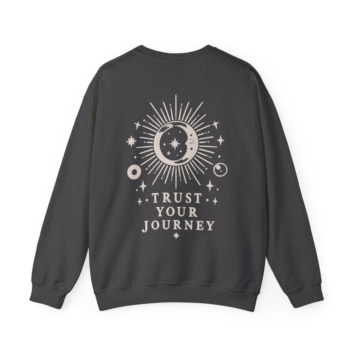 A dark charcoal gray crewneck sweatshirt with a cream celestial graphic on the back featuring a sun, moon, stars, and the text 'TRUST YOUR JOURNEY'.