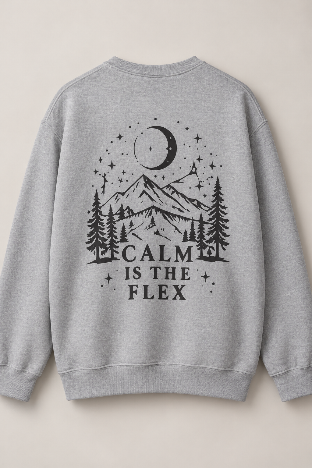 A light gray crewneck sweatshirt shown from the back, featuring a black graphic print of a mountain, pine trees, stars, and a crescent moon with the text 'CALM IS THE FLEX'.