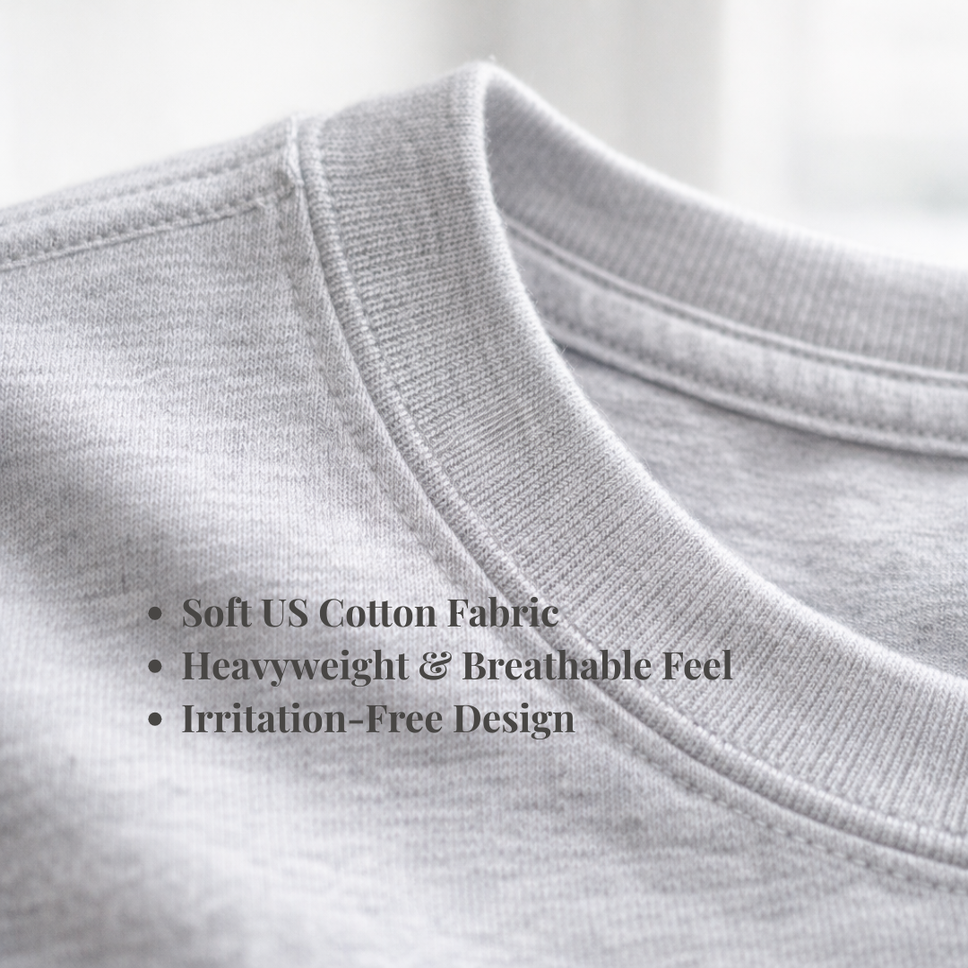 Close-up of a light gray heathered cotton t-shirt collar with text overlay detailing its soft cotton fabric, breathable feel, and irritation-free design.